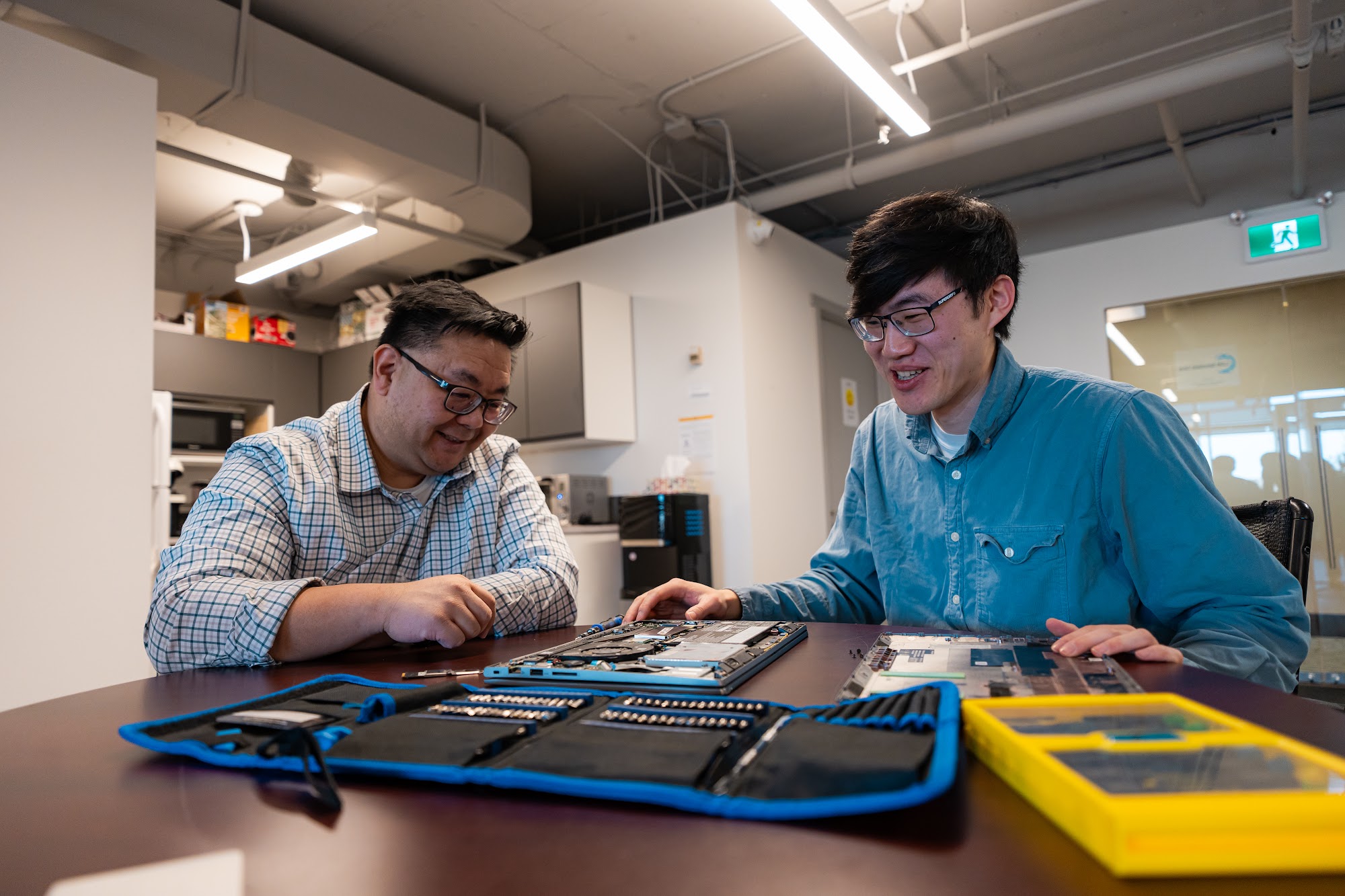 LAN technicians working together on a laptop in the Calgary office