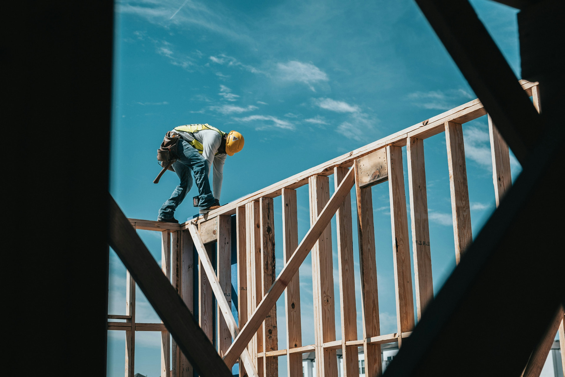 Construction worker in a hard hat building the wall frame of a new home